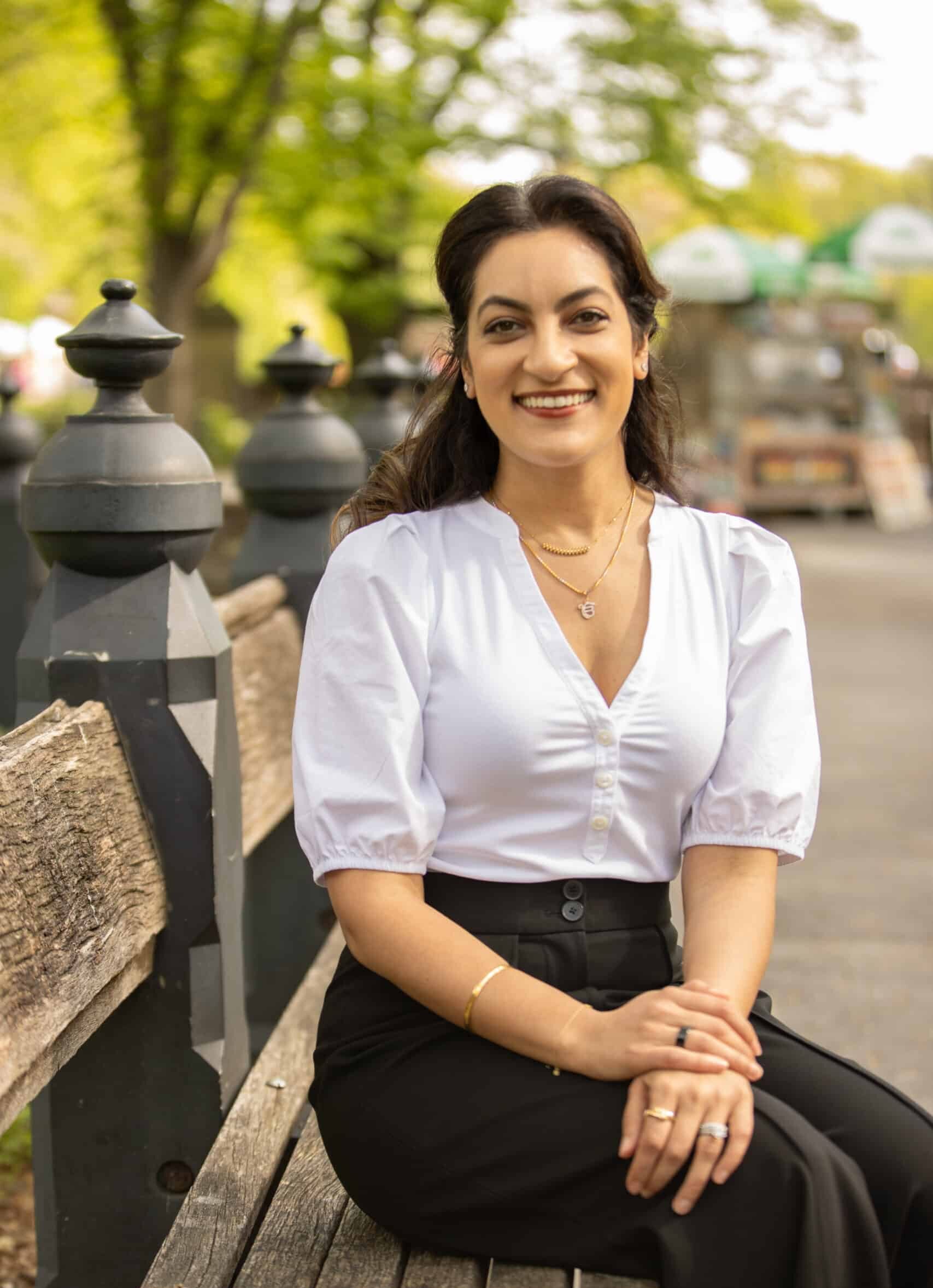 Dr. Sidak Singh, founder of Columbus Park Dental, on a bench in Central Park